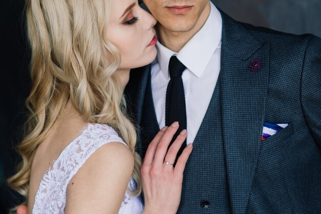 Un couple de mariés mignons à l'intérieur d'un studio classique décoré ils s'embrassent et s'étreignent