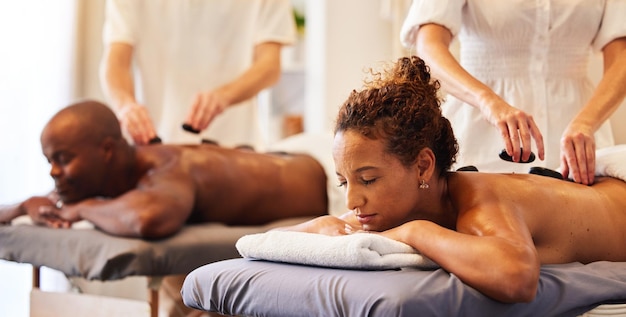 Photo couple massage rock ou spa thérapeute pour se détendre traitement de luxe ou de bien-être pour les soins de santé ou zen au centre de villégiature salon de beauté ou femme et homme noirs pour des soins de la peau ou une thérapie sains