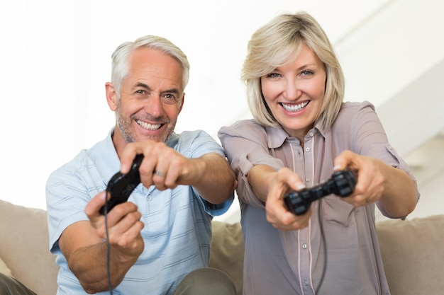 Couple mature gai, jeu vidéo sur canapé