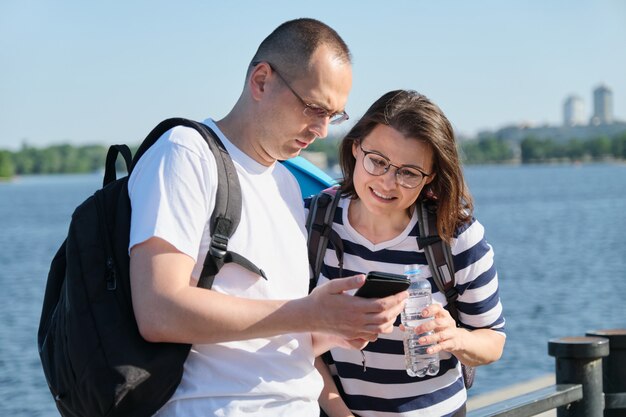 Couple mature en plein air à l'aide de smartphone