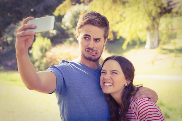 Couple mignon faisant selfie dans le parc