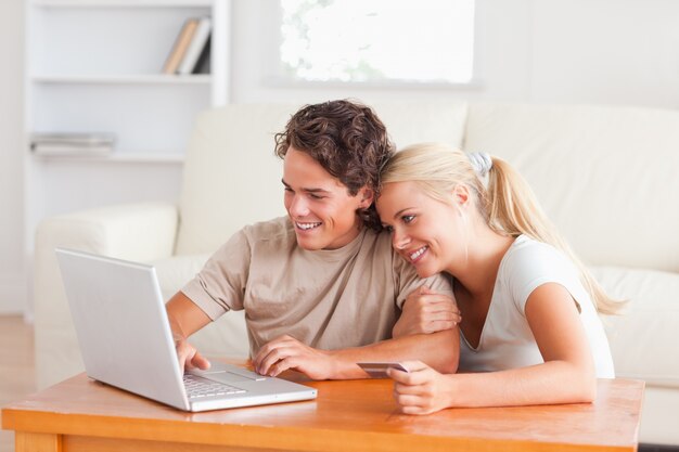 Couple mignon avec un ordinateur portable et une carte de crédit
