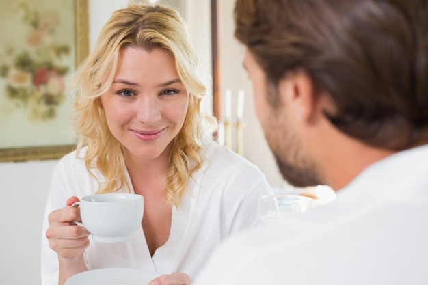 Couple mignon en peignoirs ayant un café ensemble