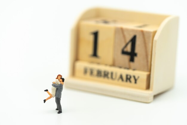 Couple miniature 2 personnes debout sur fond blanc. Le jour 14 rencontre la Saint Valentin.