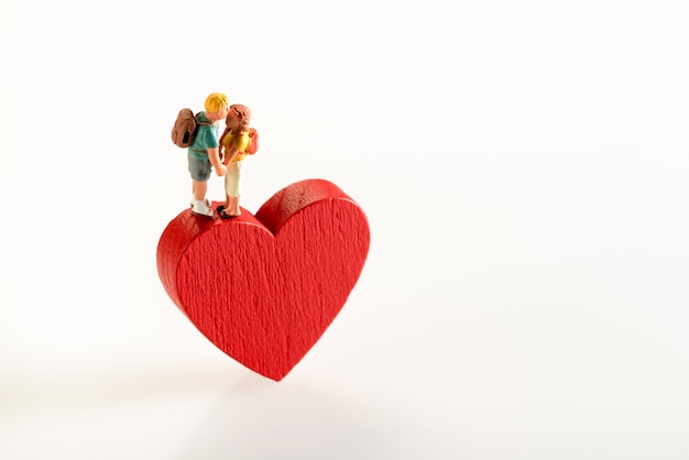 Couple miniature amoureux tenant sur une forme de coeur