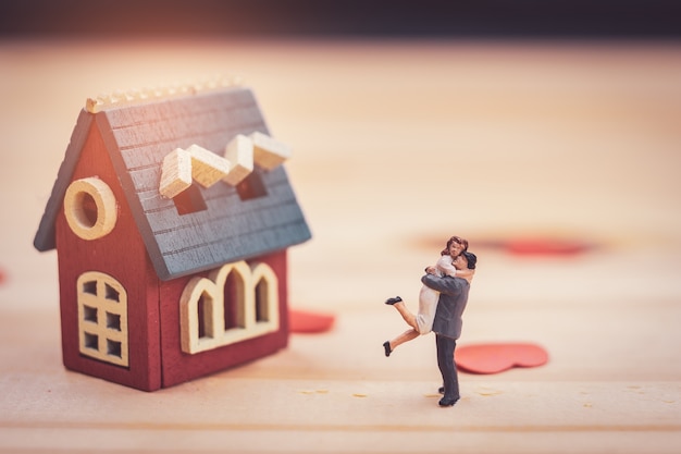 Photo couple miniature avec maison miniature