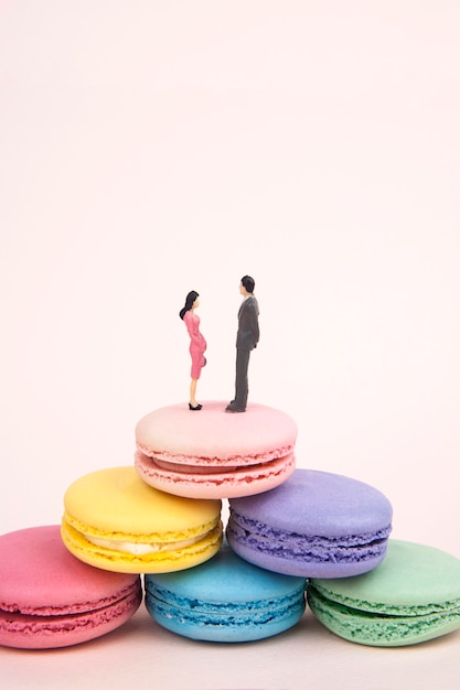 couple miniature sur la pyramide de macarons colorés