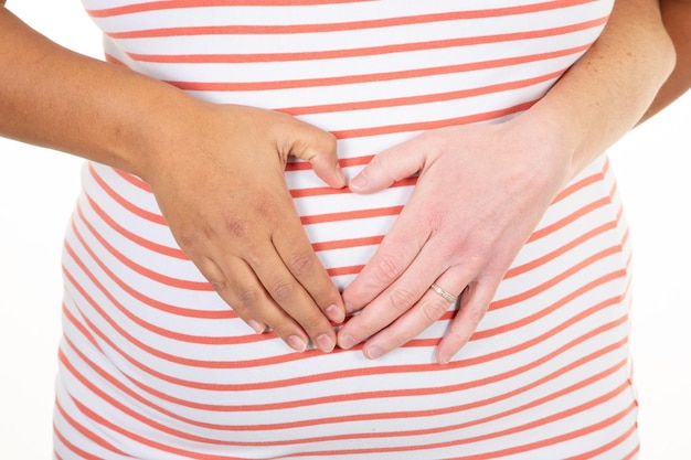 Couple mixte enceinte lesbienne attendant leur enfant femmes blanches noires mains sur le cœur les filles aiment la grossesse lgbt