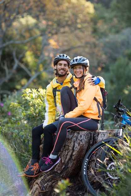 Couple de motards assis sur une souche d'arbre