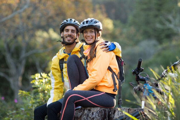 Couple de motards assis sur une souche d'arbre