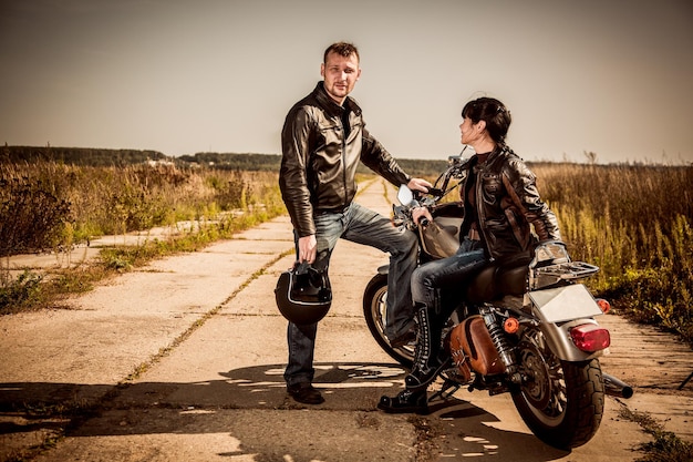 Couple de motards Homme et femme près d'une moto sur la route