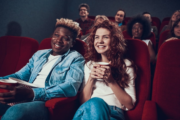 Couple multiethnique regarde un film dans une salle de cinéma