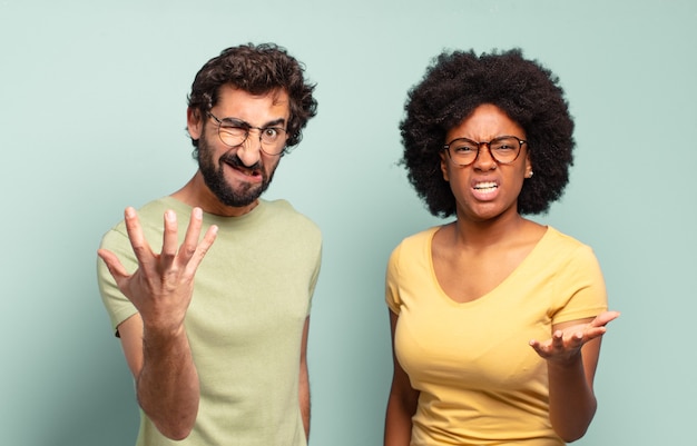 Photo couple multiracial d'amis semblant en colère, agacé et frustré de crier ce qui ne va pas