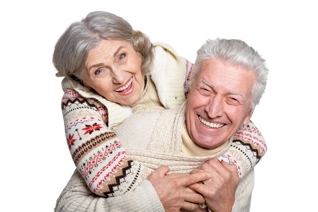 un couple mûr souriant posant sur un fond blanc