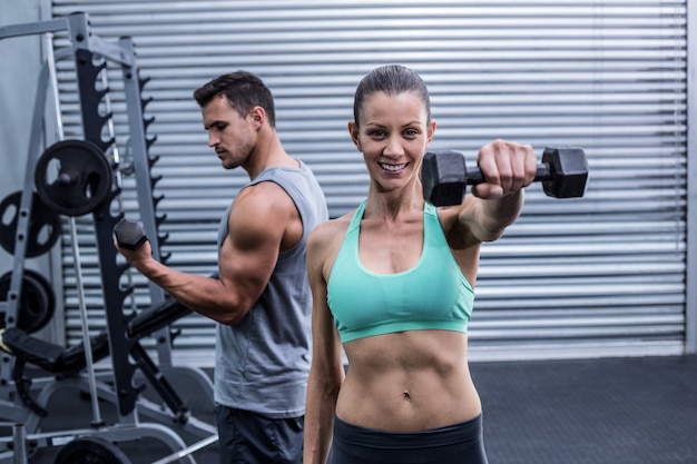 Un couple musclé soulevant des haltères