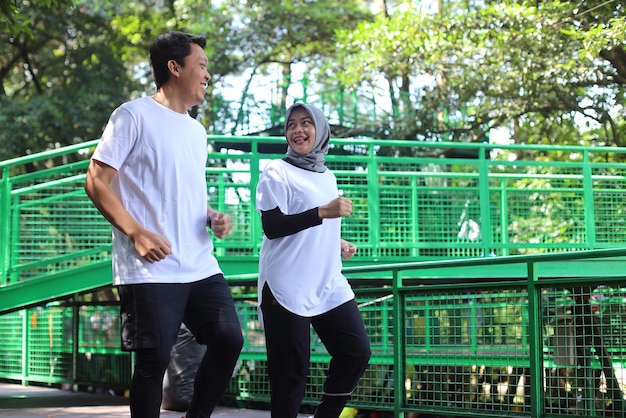 Couple musulman faisant du jogging et courant à l'extérieur dans la nature. Concept de mode de vie familial sain.