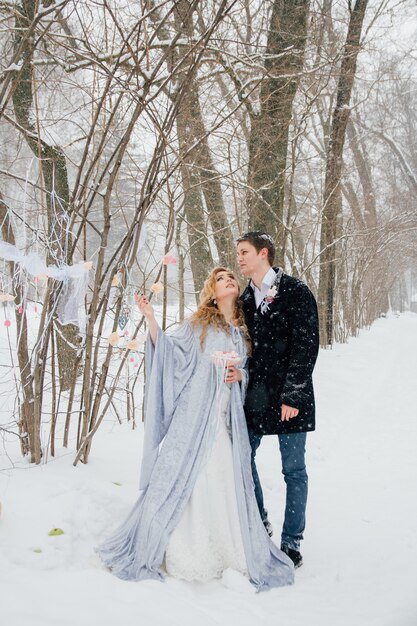 Couple sur la nature en hiver lors d'une chute de neige