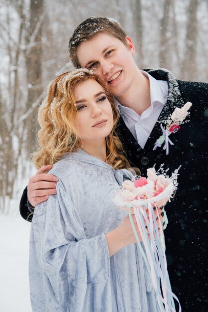 Couple sur la nature en hiver lors d'une chute de neige