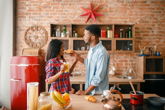 Couple noir ludique s'amusant dans la cuisine.