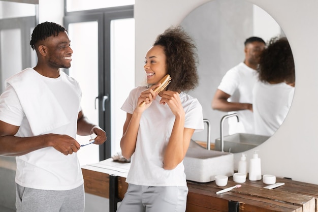 Un couple noir se prépare tranquillement ensemble en passant du temps dans la salle de bain.