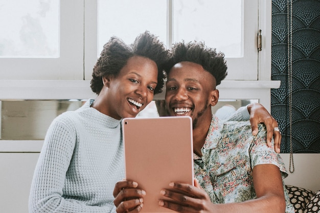 Couple noir utilisant une tablette ensemble