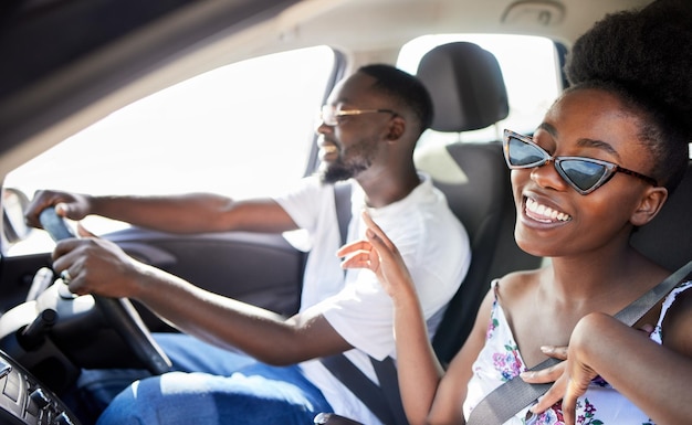 Couple noir voyage sur la route ou liberté dans les voyages en voiture pendant les vacances d'amour d'été aventure ou vacances de lieu Souriez heureux et faites confiance à un homme ou à une femme comique chantant pour danser de la musique avec de l'énergie ou des lunettes de soleil