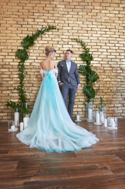 Couple nouvellement marié, couple amoureux avant le mariage. Homme et femme s'aimant. La mariée en robe turquoise et le marié en costume bleu. Décor de mariage, zone de photo de mariage