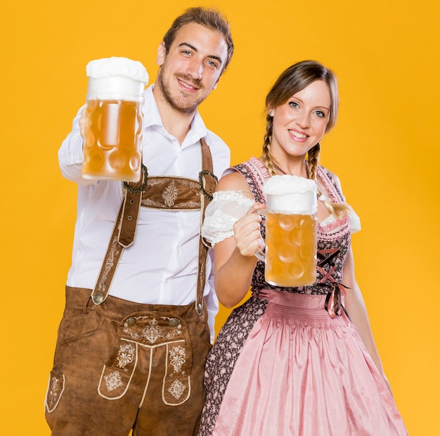 Couple d'Oktoberfest tenant des chopes de bière