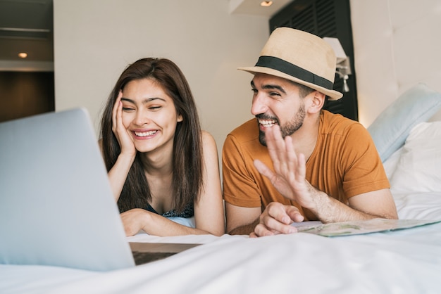 Couple organisant leur voyage en chambre d'hôtel.