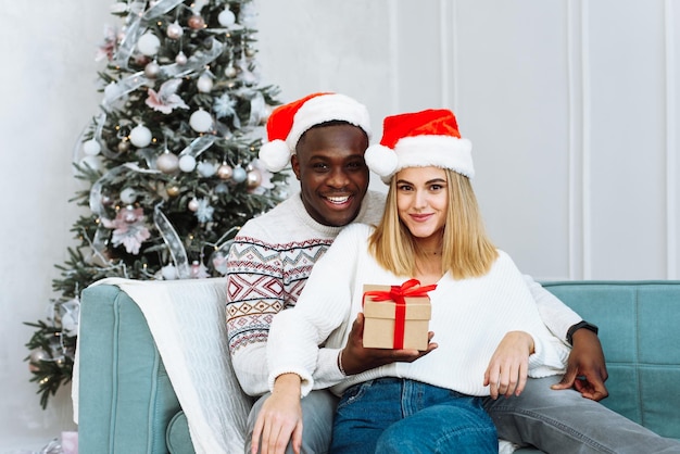 Couple partageant un cadeau de Noël Portrait d'un beau couple pendant la période de Noël