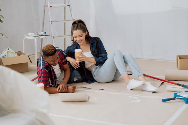 Un couple passe du temps dans un nouvel appartement à redécorer la peinture des murs de la chambre