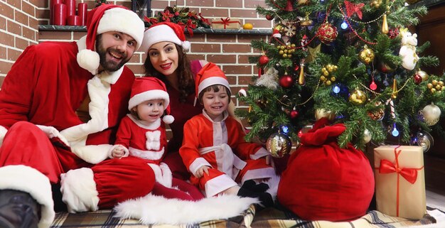 Couple de père Noël avec arbre de Noël pour enfants