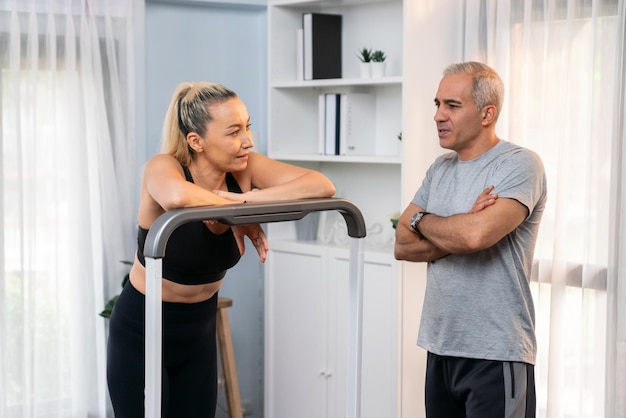 Couple de personnes âgées actives courant sur une machine à courir à la maison ensemble pour un mode de vie sain et des soins du corps après la retraite pour le retraité Clout