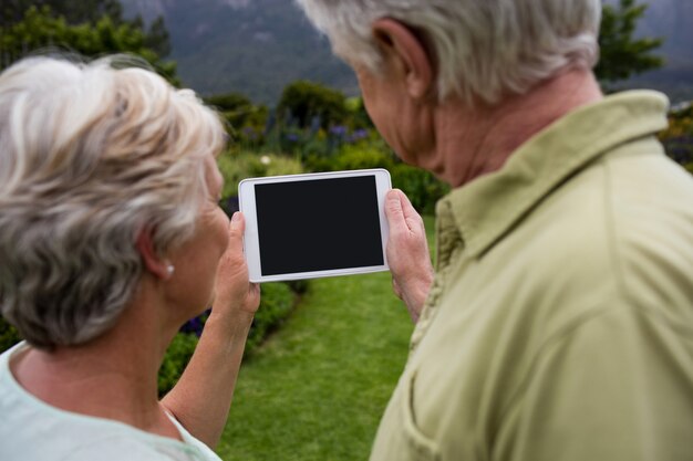 Couple de personnes âgées à l'aide de tablette numérique