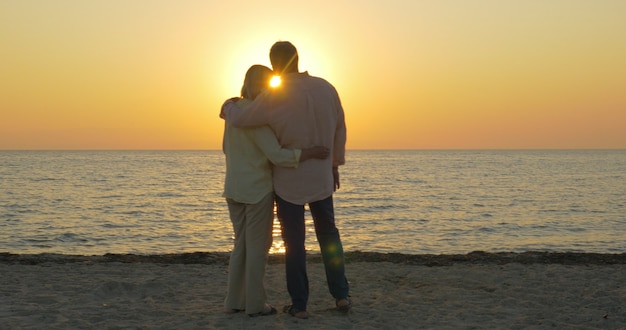 Couple de personnes âgées aimant le coucher de soleil sur la mer