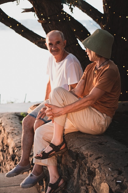 Couple de personnes âgées amoureux assis et discutant dans un parc