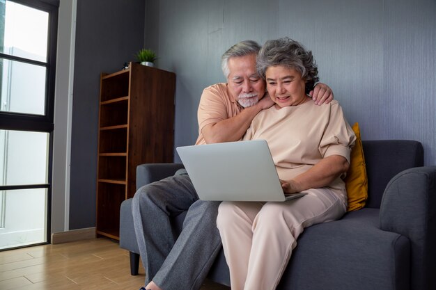 Couple de personnes âgées asiatiques parler dans le chat d'appel vidéo sur un ordinateur portable, la technologie intelligente pour la vieillesse et l'activisme en ligne rester connecté concept