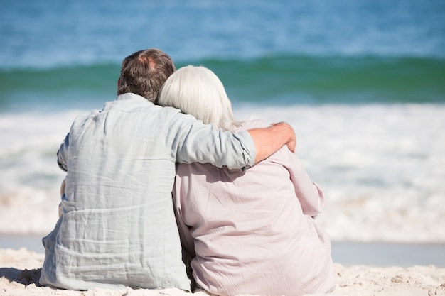 Couple de personnes âgées assis sur la plage