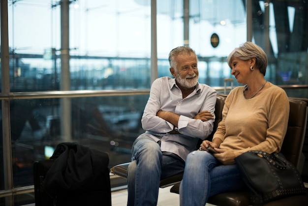 Couple de personnes âgées en attente d&#39;embarquement à l&#39;intérieur de l&#39;aéroport