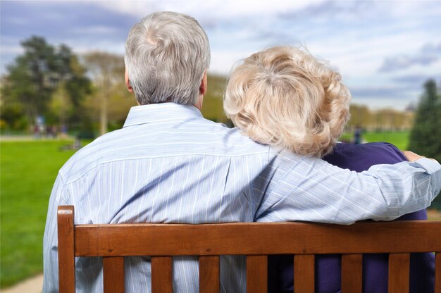 Couple de personnes âgées sur banc de parc