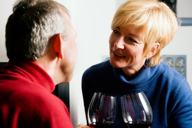 Couple de personnes âgées buvant du vin rouge