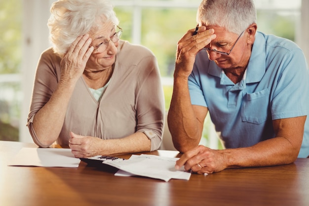 Couple de personnes âgées comptant des factures à la maison