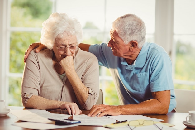 Couple de personnes âgées comptant des factures à la maison