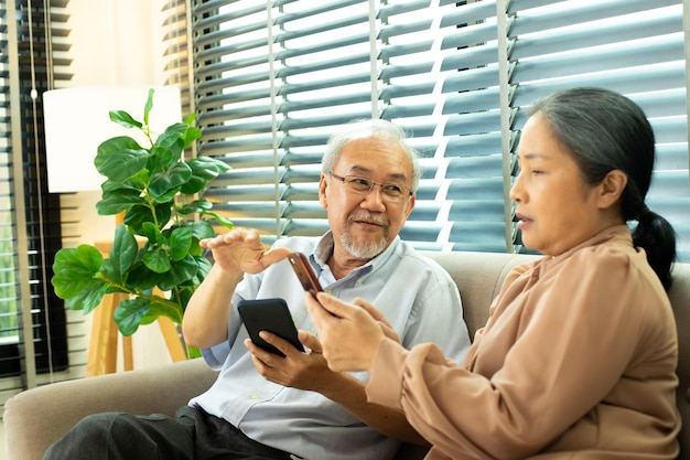 Un couple de personnes âgées a une conversation ensemble après la retraite Le mari épouse une personne a une pension pour un moment romantique avec le sourire heureux de profiter des médias sociaux sur Internet sur l'espace de copie du téléphone intelligent numérique