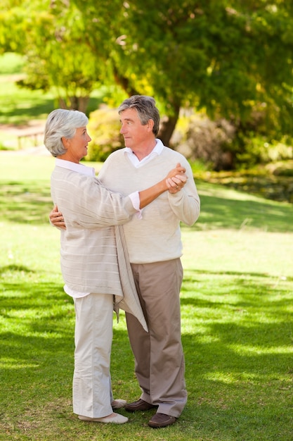 Couple de personnes âgées dansant dans le parc