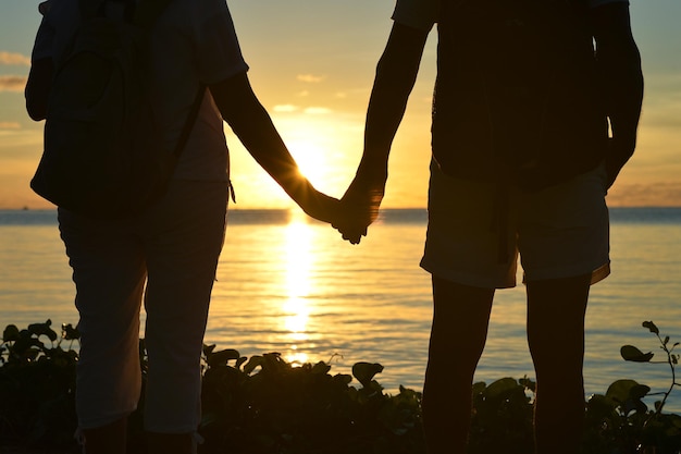 Couple de personnes âgées debout au bord de la mer