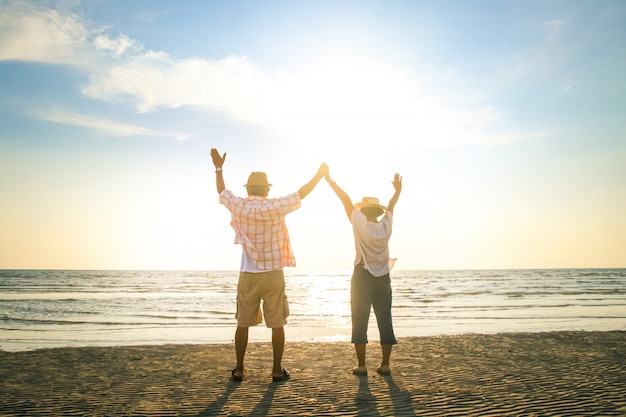 Couple de personnes âgées debout sur la plage