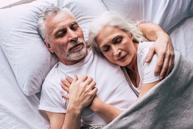 Photo le couple de personnes âgées dormant sur le lit