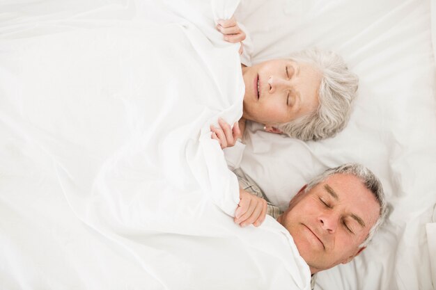 Couple de personnes âgées dormir dans un lit