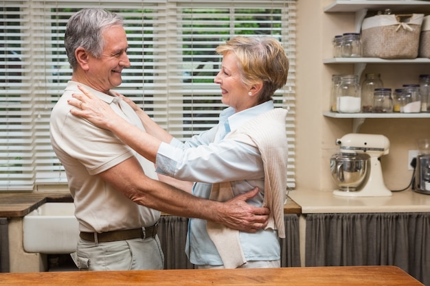 Couple de personnes âgées étreindre et souriant